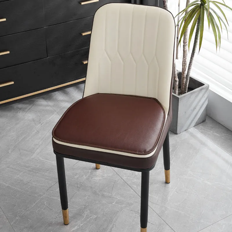 Orange leather horseshoe-shaped seat cushion on a wooden dining chair.