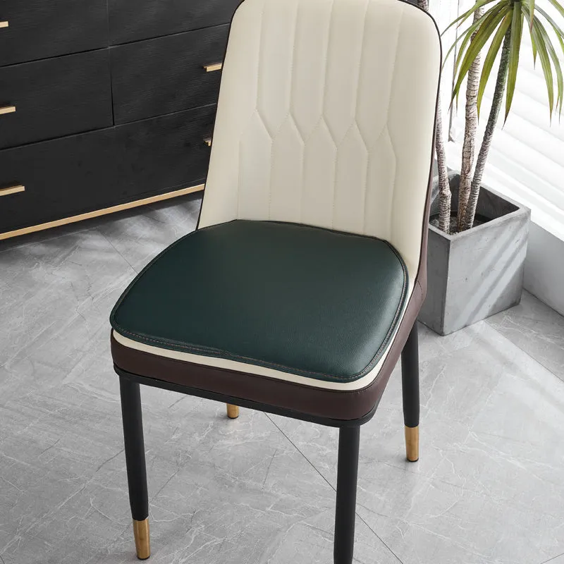 Orange leather horseshoe-shaped seat cushion on a wooden dining chair.