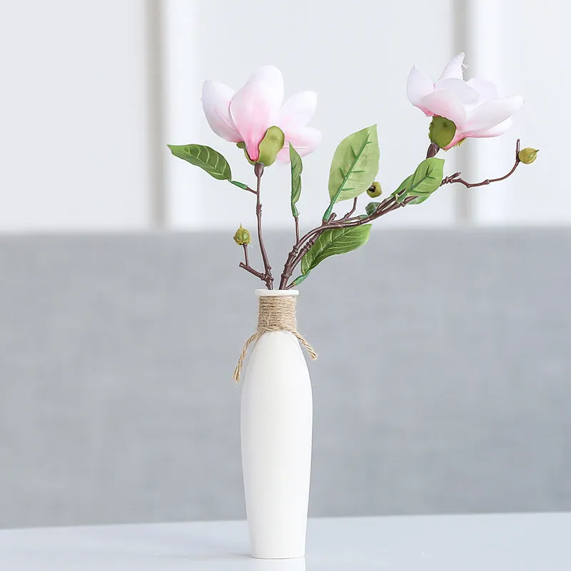 Modern simple ceramic vase with artificial dried flower arrangement on a countertop, medium size
