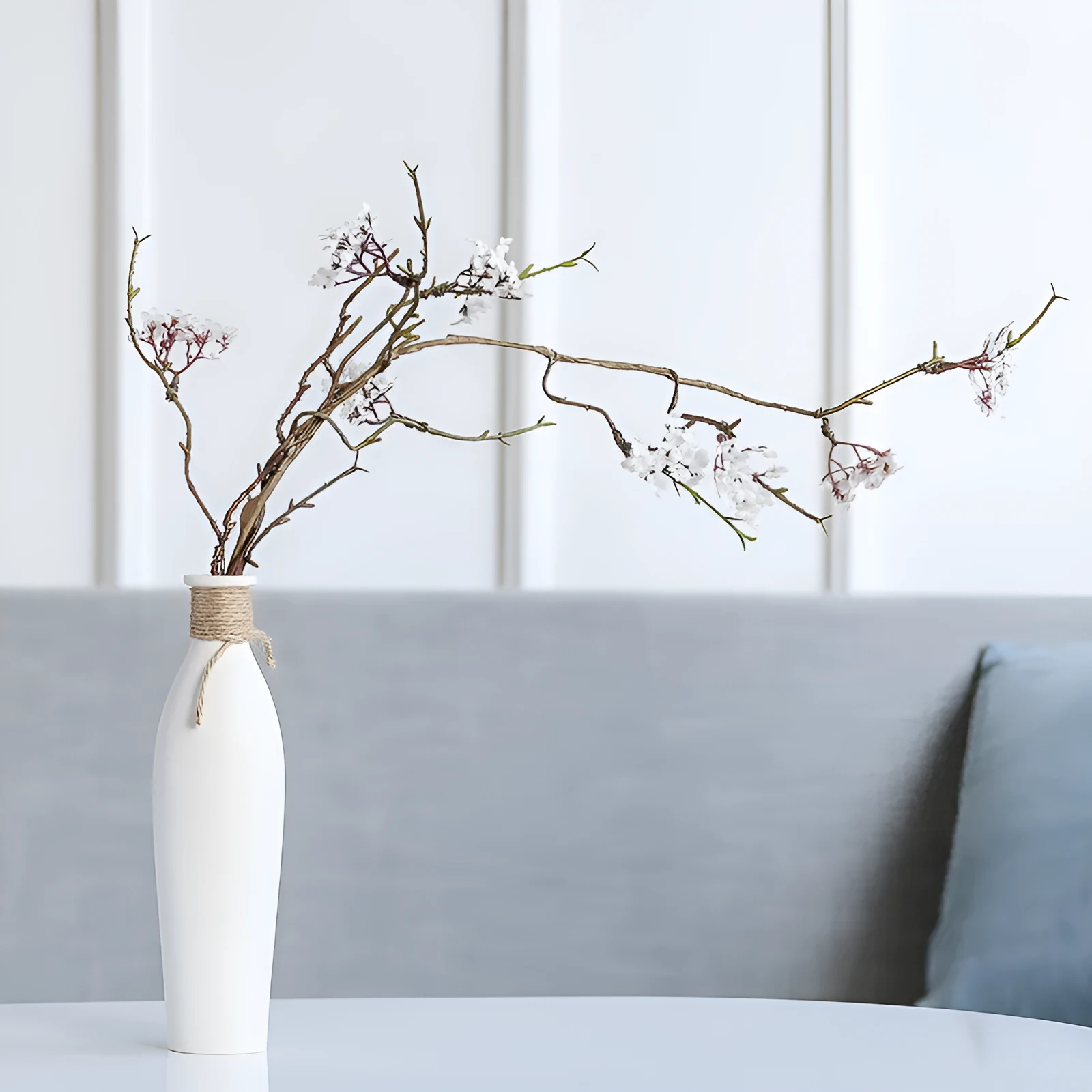 Modern simple ceramic vase with artificial dried flower arrangement on a countertop, medium size