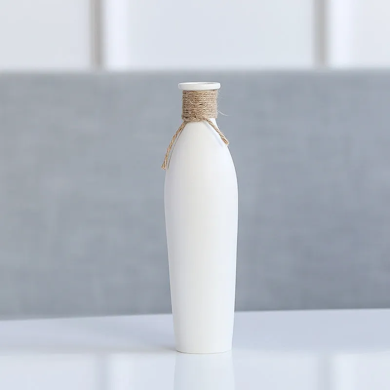 Modern simple ceramic vase with artificial dried flower arrangement on a countertop, medium size