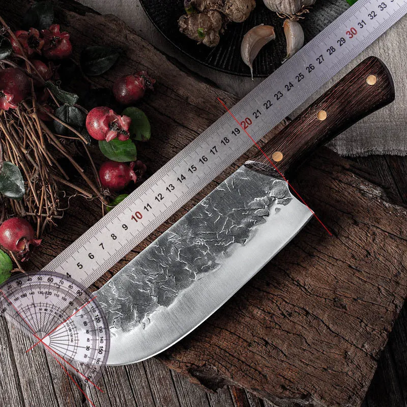 Hand forged stainless steel butcher knife with chicken wing wood handle and copper nails on a cutting board