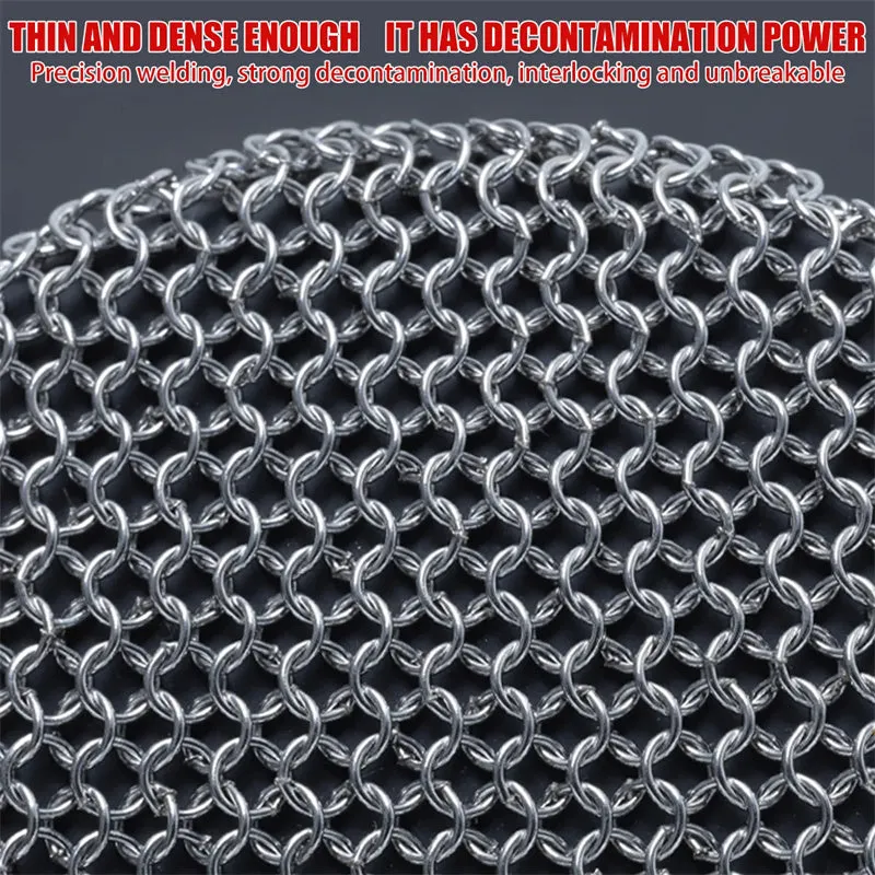 Round 316 stainless steel chainmail scrubber with red silicone handle on cast iron skillet