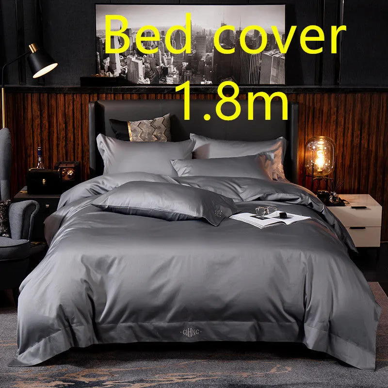 Four-piece cotton satin quilted bedding set with duvet cover, sheet, and pillowcases in a bedroom setting