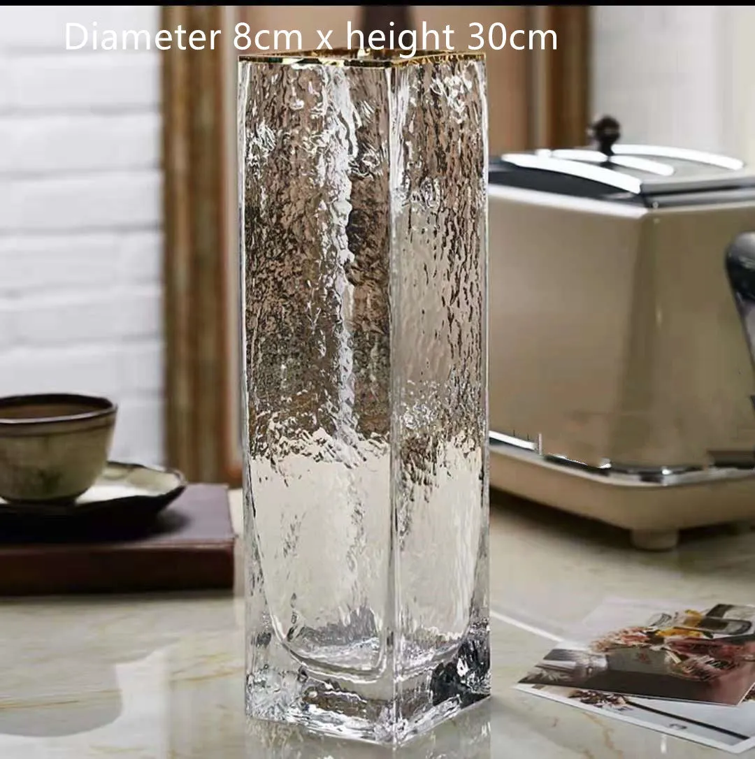 Transparent gold-painted glass vase on plain background