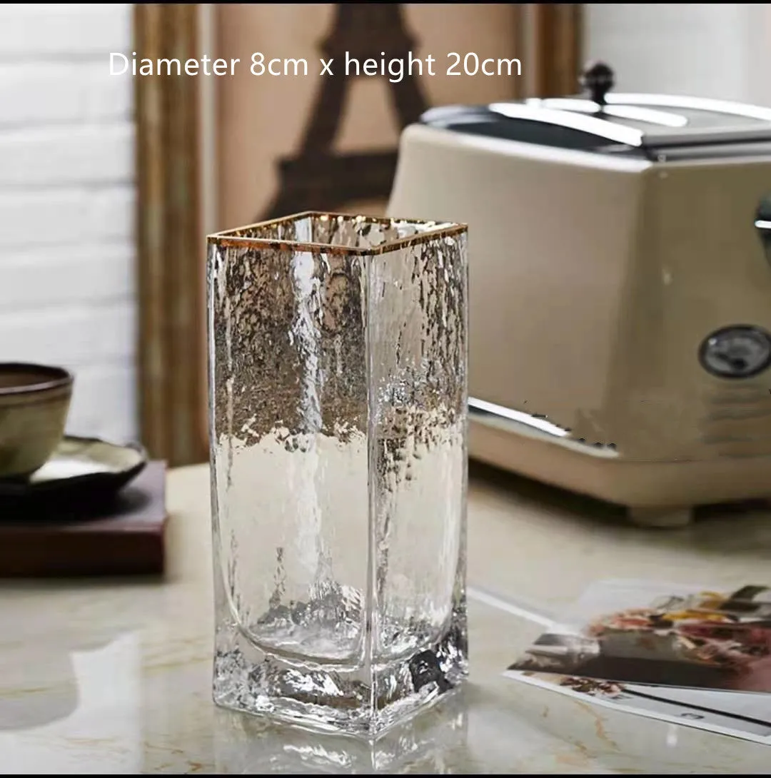 Transparent gold-painted glass vase on plain background