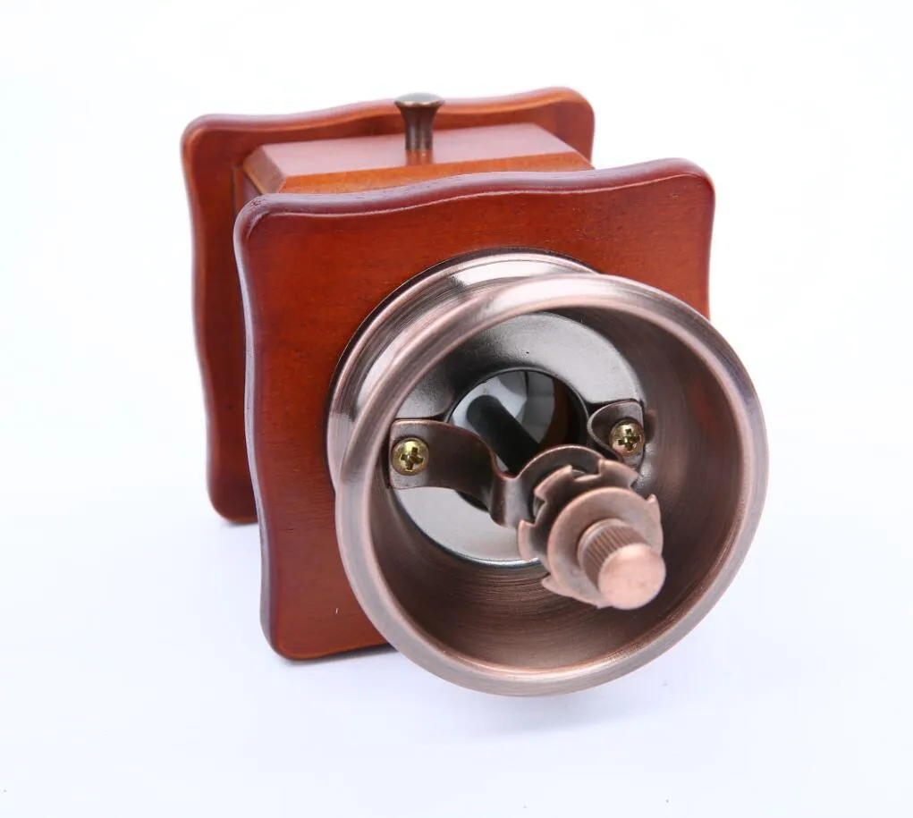Red manual coffee grinder with ceramic burr and cast iron handle, 10x10x17cm, on a wooden surface