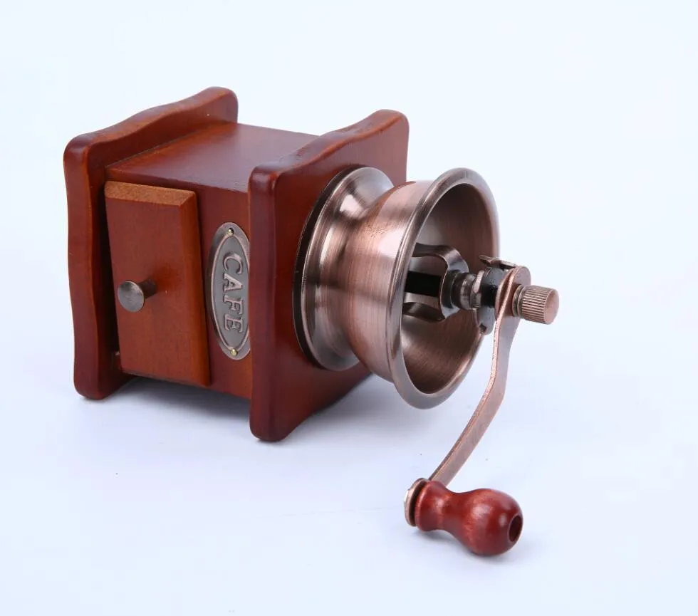 Red manual coffee grinder with ceramic burr and cast iron handle, 10x10x17cm, on a wooden surface