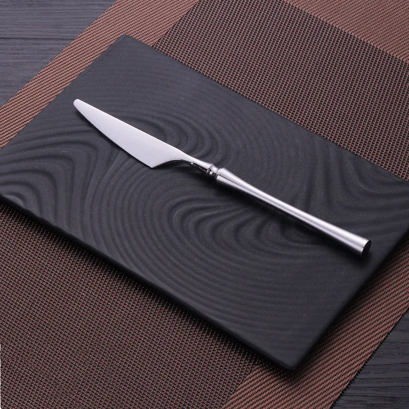 Stainless steel cutlery set with main knife, main fork, main spoon, and teaspoon in silver finish