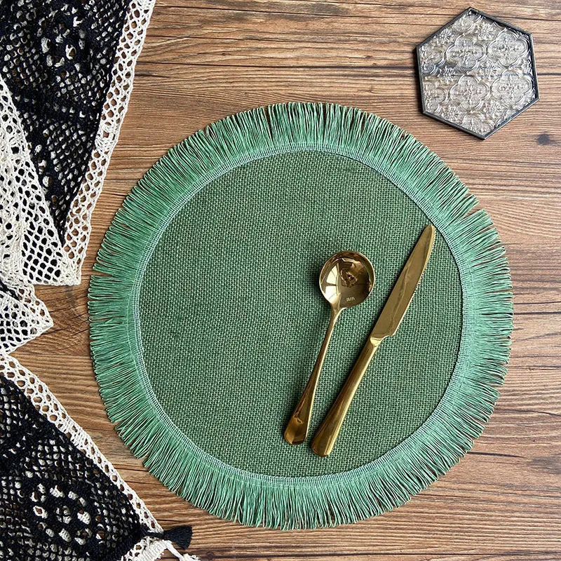 Handwoven round jute placemat with tassel edge in original hemp colour on a wooden table