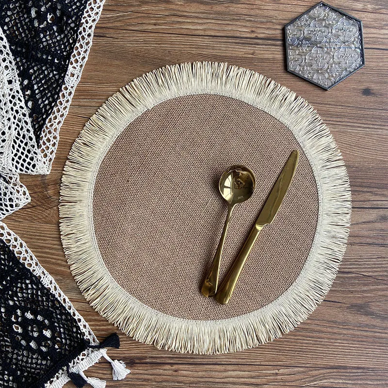 Handwoven round jute placemat with tassel edge in original hemp colour on a wooden table
