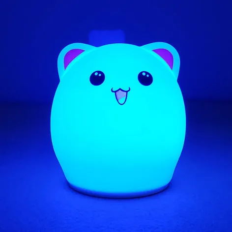 Cartoon silicone clap lamp in blue with warm white light mode on a wooden bedside table