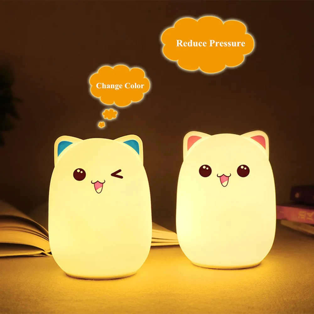 Cartoon silicone clap lamp in blue with warm white light mode on a wooden bedside table