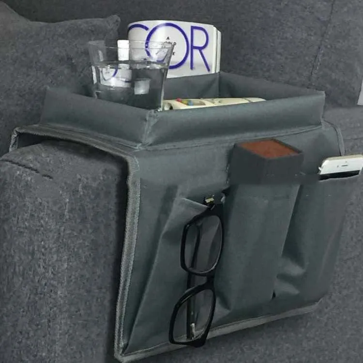 Black Oxford fabric sofa armrest organiser bag with 6 pockets on a couch handrail