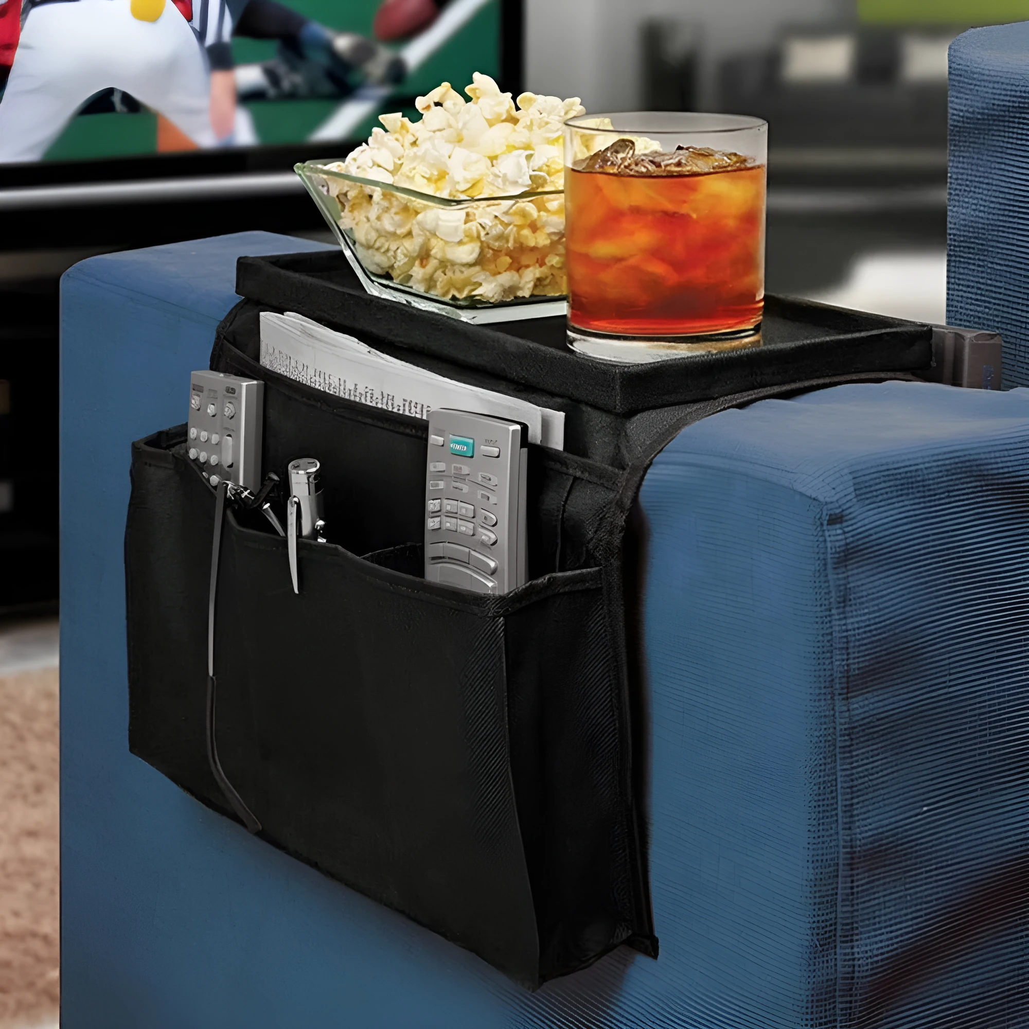 Black Oxford fabric sofa armrest organiser bag with 6 pockets on a couch handrail