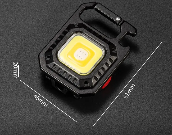 Black multifunctional portable LED torch with aluminium alloy body, magnet base, and control button on a wooden surface