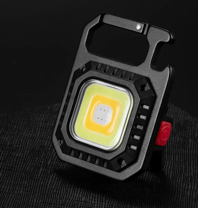 Black multifunctional portable LED torch with aluminium alloy body, magnet base, and control button on a wooden surface