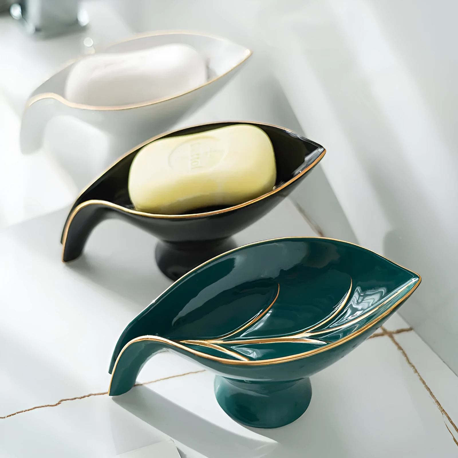 Ceramic leaf shape soap dish with drainage holes and suction cup in white on bathroom counter