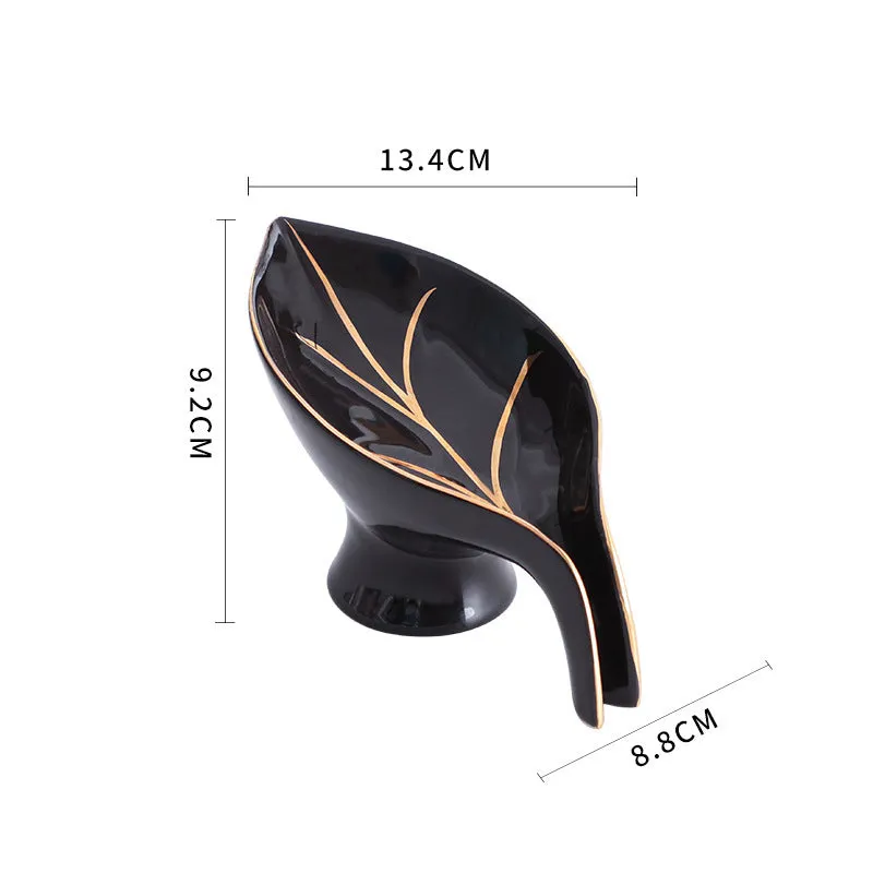 Ceramic leaf shape soap dish with drainage holes and suction cup in white on bathroom counter