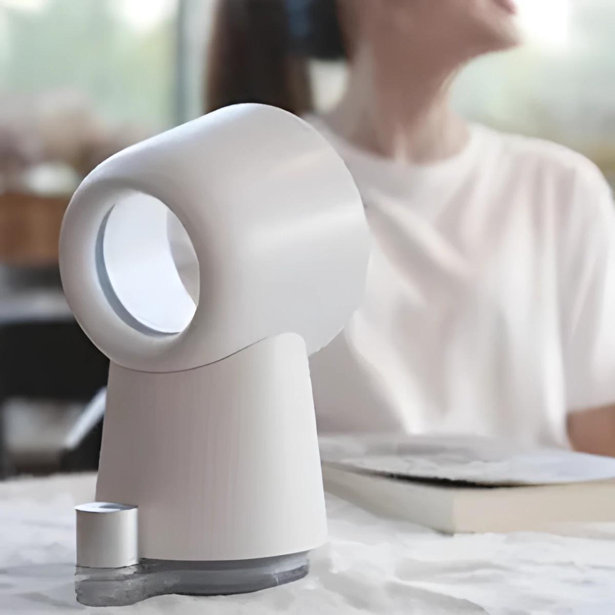 White desktop bladeless fan with USB power and humidification spray on a desk