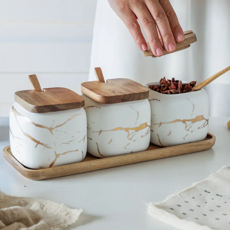 Nordic gold marble ceramic jar set with wooden tray and bamboo spoon on a kitchen counter