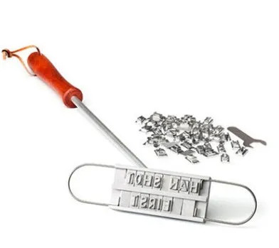 Silver aluminium alloy BBQ branding iron with 55 letters and 8 spaces for personalised meat stamping on a wooden surface