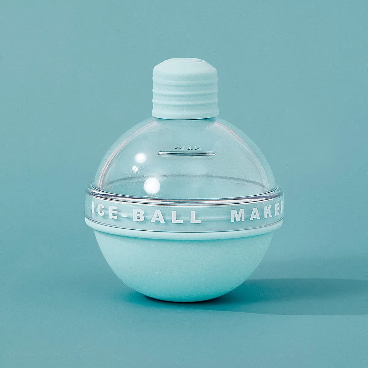 Blue spherical silicone ice ball mold producing a 6cm clear ice ball for whiskey, on a wooden table