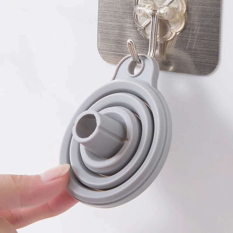 Creative silicone folding funnel in grey and white, collapsed flat on a kitchen surface