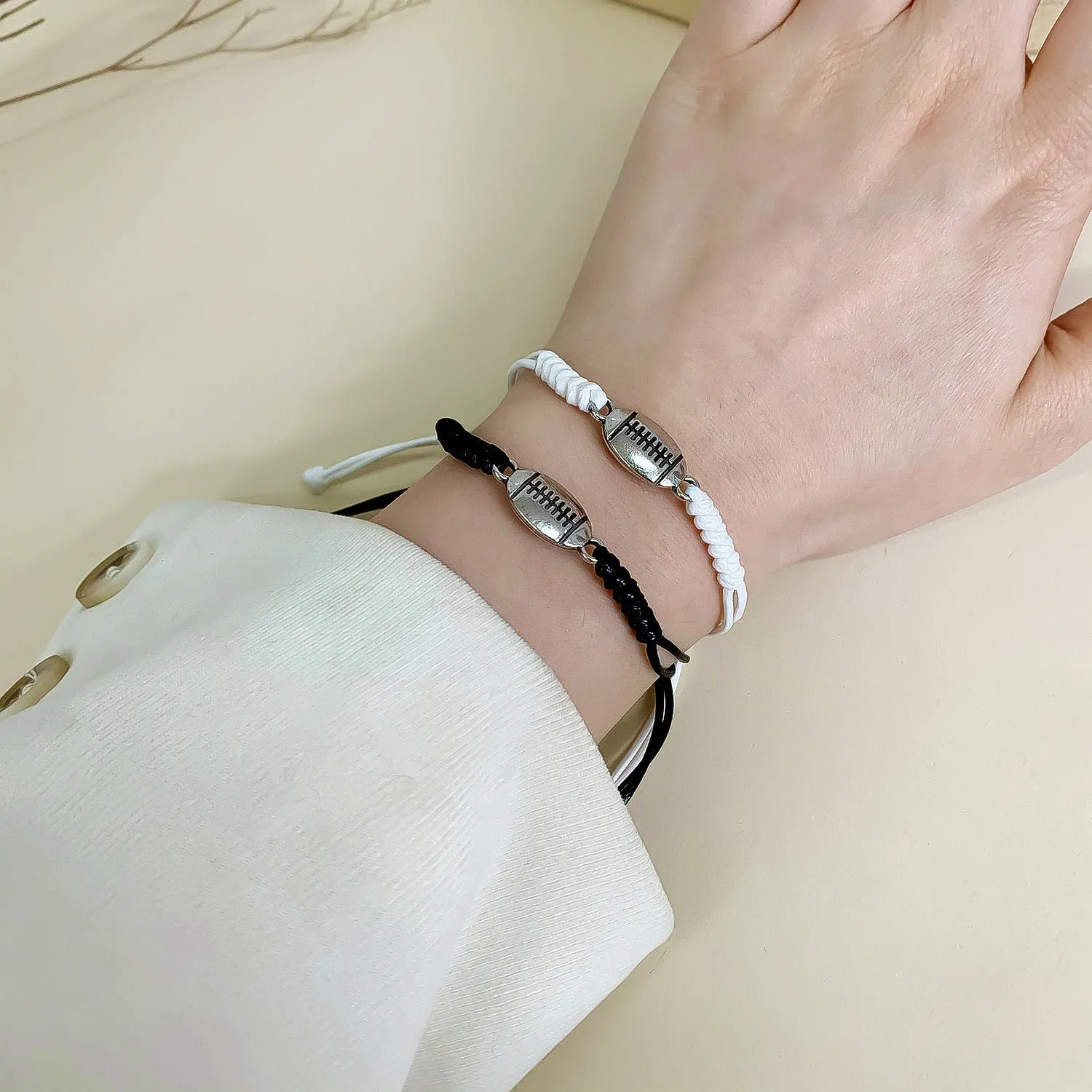 Black and white mixed colour alloy electroplated sports bracelet with geometric square shape on neutral background