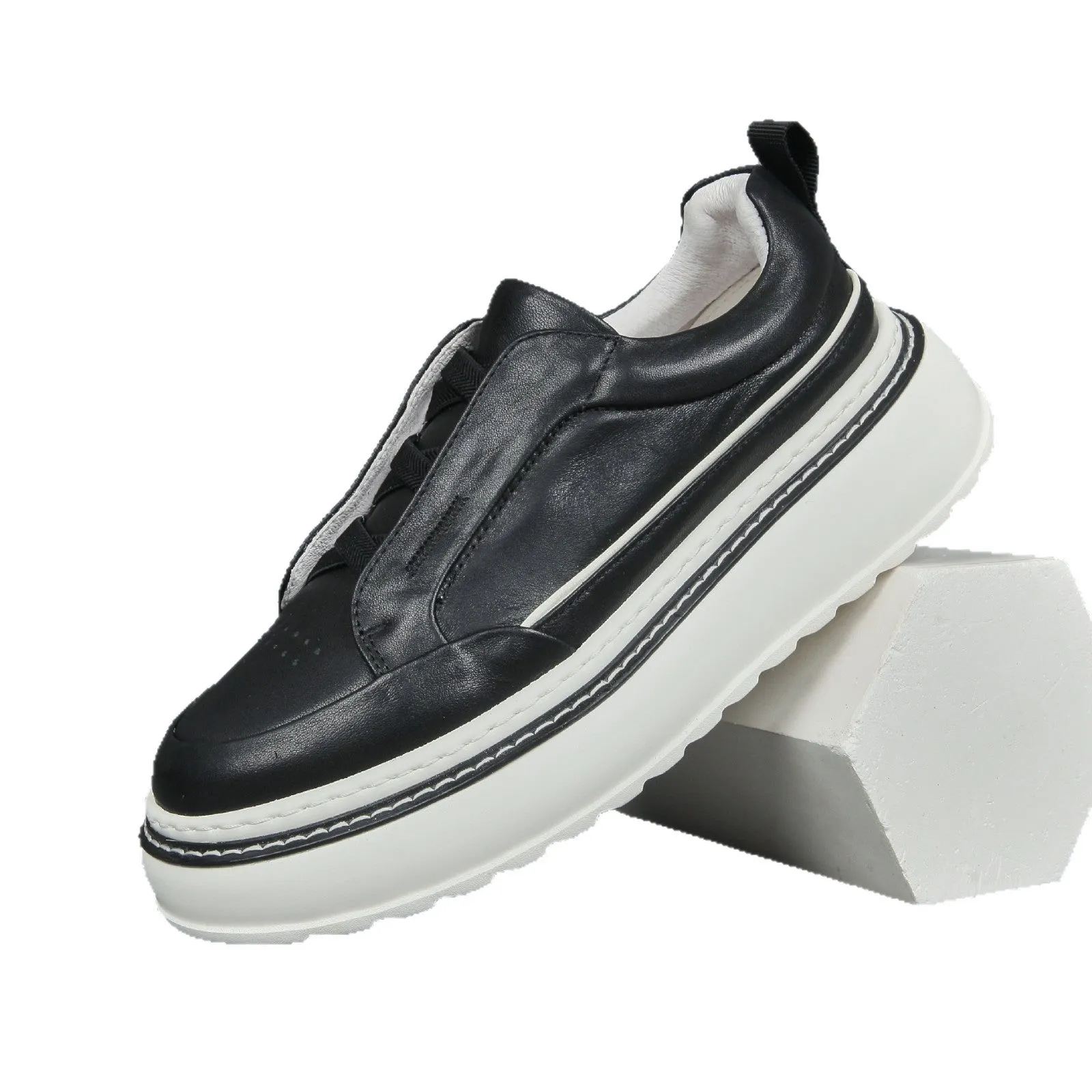 Black casual slip-on sneaker with leather upper, foam platform sole, and elastic band – side view