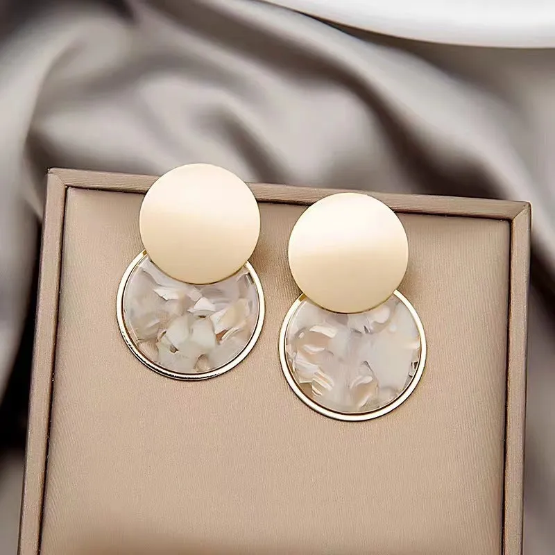 Retro personalized round matte resin female earrings with rotundity shape on a neutral background