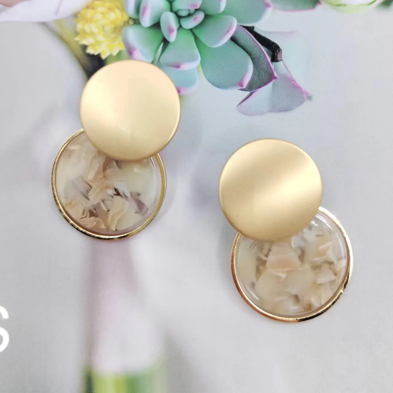 Retro personalized round matte resin female earrings with rotundity shape on a neutral background