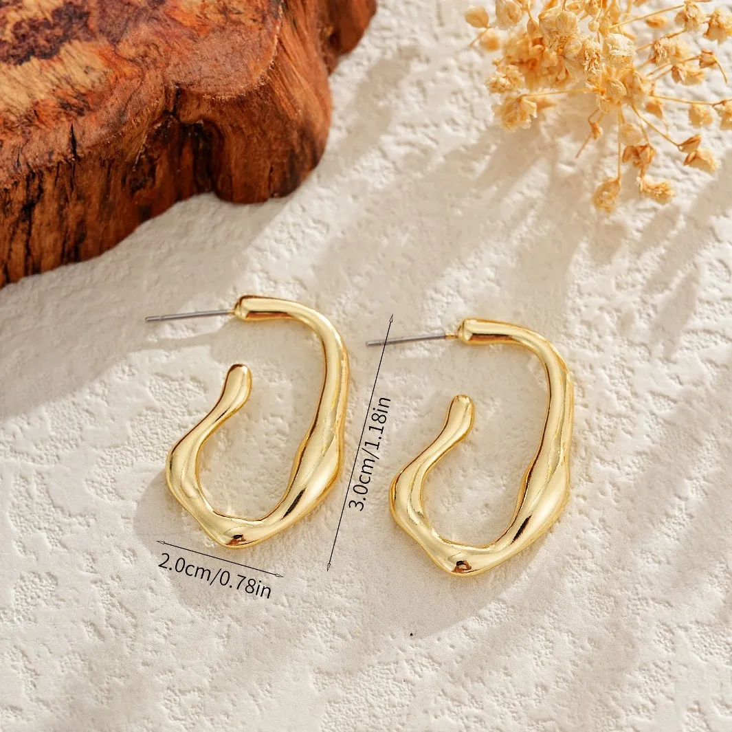Gold irregular shaped minimalist drop earrings with abstract geometric design on neutral background