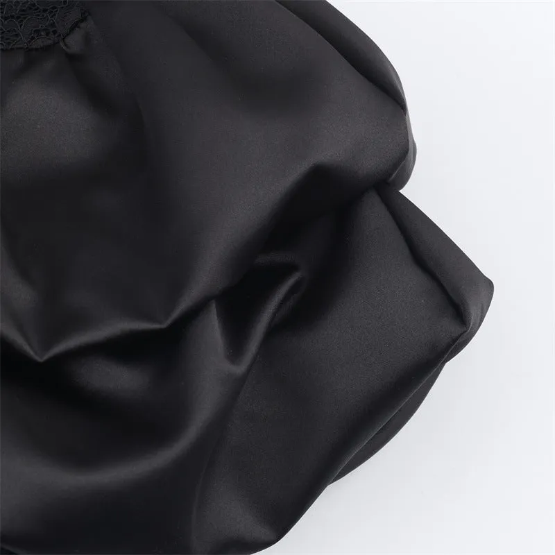 Women's black cotton short dress with lace stitching and asymmetric skirt on a plain background