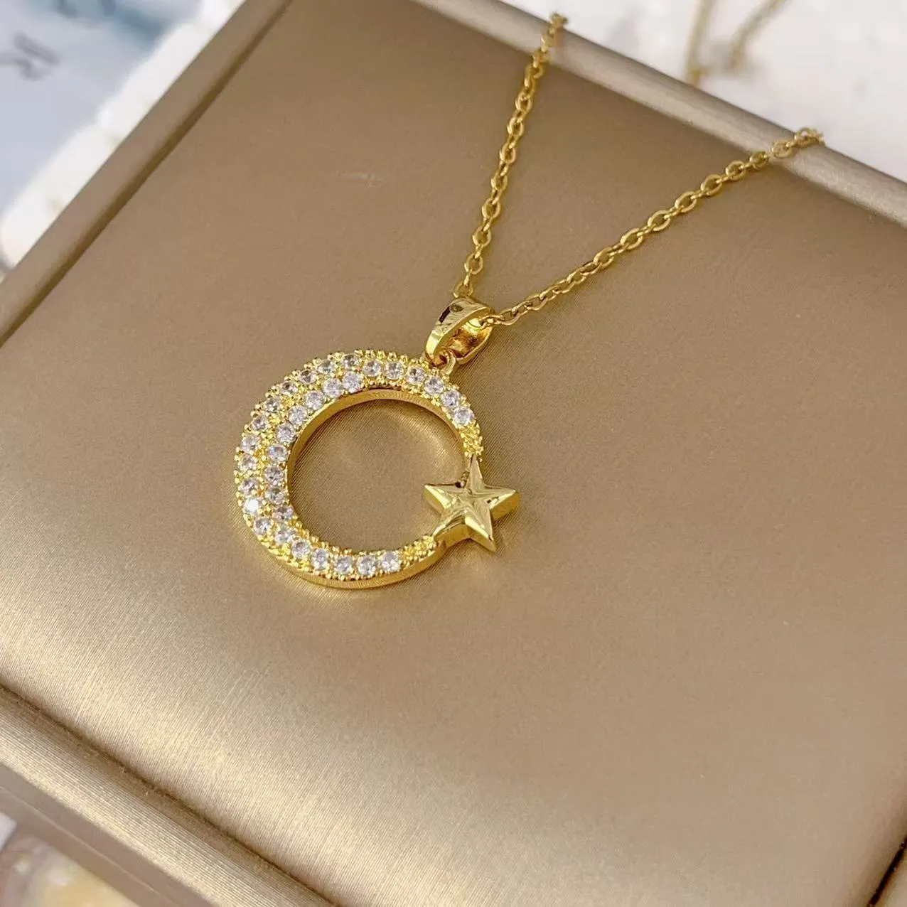 Xingyue gold geometric moon pendant necklace with zircon stone on titanium steel O-ring chain against white background