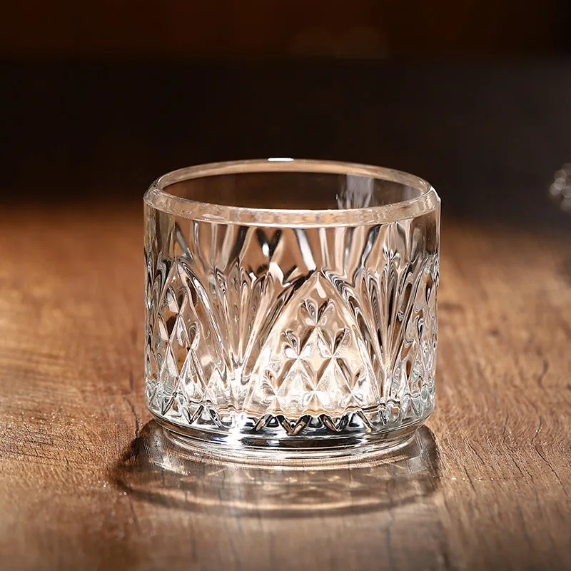 Stackable engraved glass wine glasses and sake barrel on a table