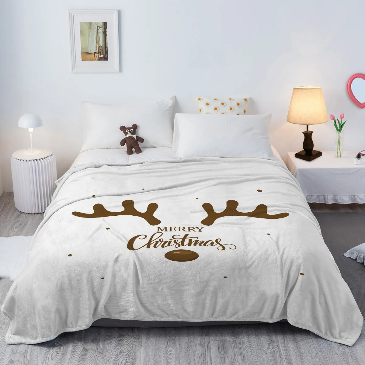 White flannel velvet deer antler pattern Christmas blanket on a sofa