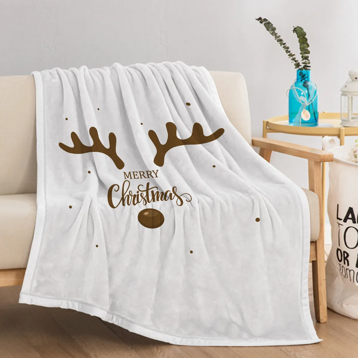 White flannel velvet deer antler pattern Christmas blanket on a sofa