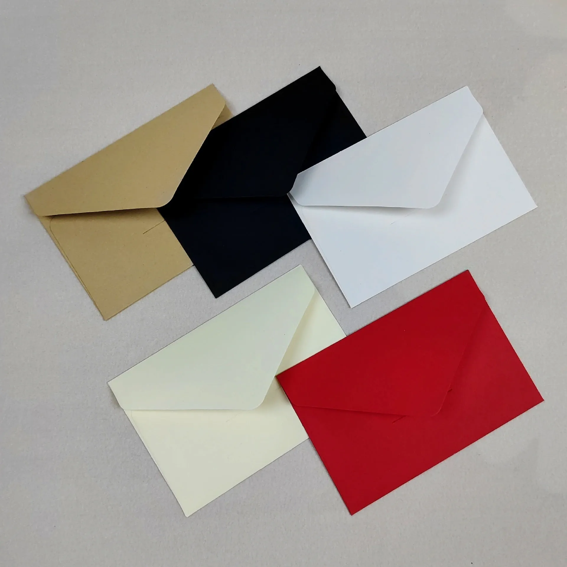 Pack of 100 kraft paper mini envelopes in beige, black, light brown, red, and white