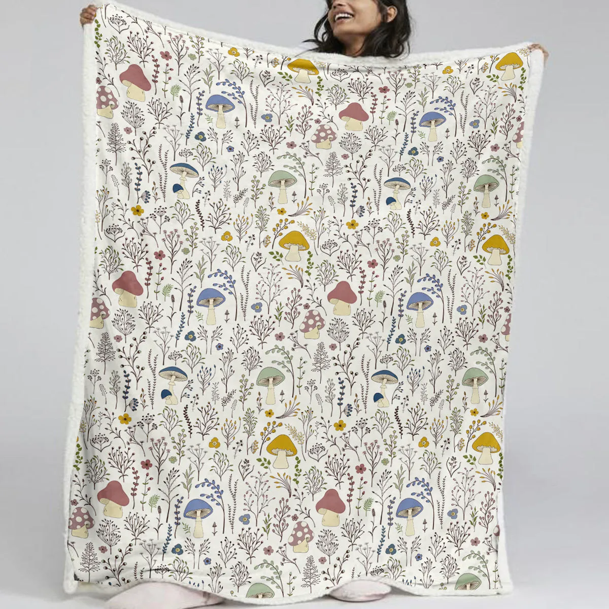 White Sherpa fleece blanket with tree leaf mushroom pattern, sized 130x150cm, on a sofa