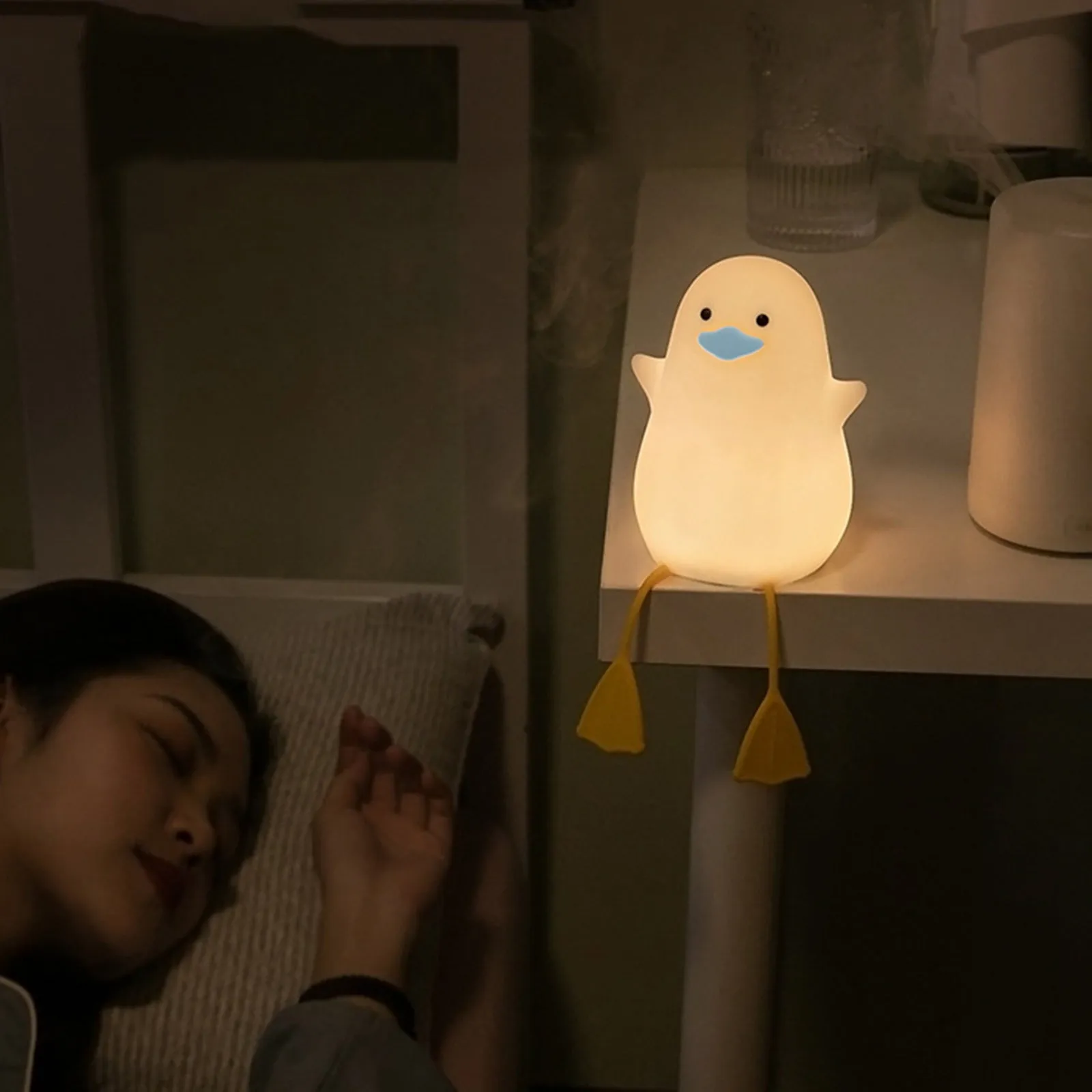 Seagull silicone night light in yellow colour with soft warm glow on bedside table