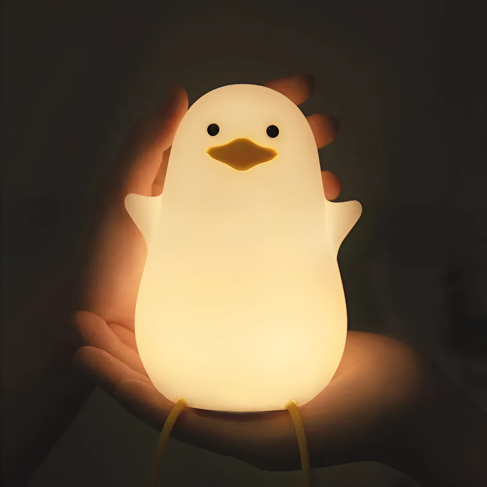 Seagull silicone night light in yellow colour with soft warm glow on bedside table