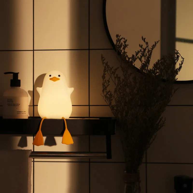 Seagull silicone night light in yellow colour with soft warm glow on bedside table