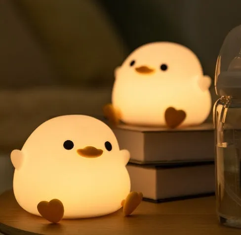 Seagull silicone night light in yellow colour with soft warm glow on bedside table