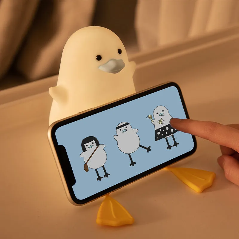 Seagull silicone night light in yellow colour with soft warm glow on bedside table
