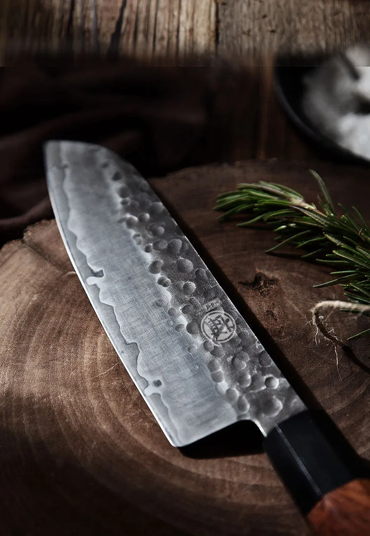 Hand forged Santoku chef knife with 149 cm silver blade on cutting board
