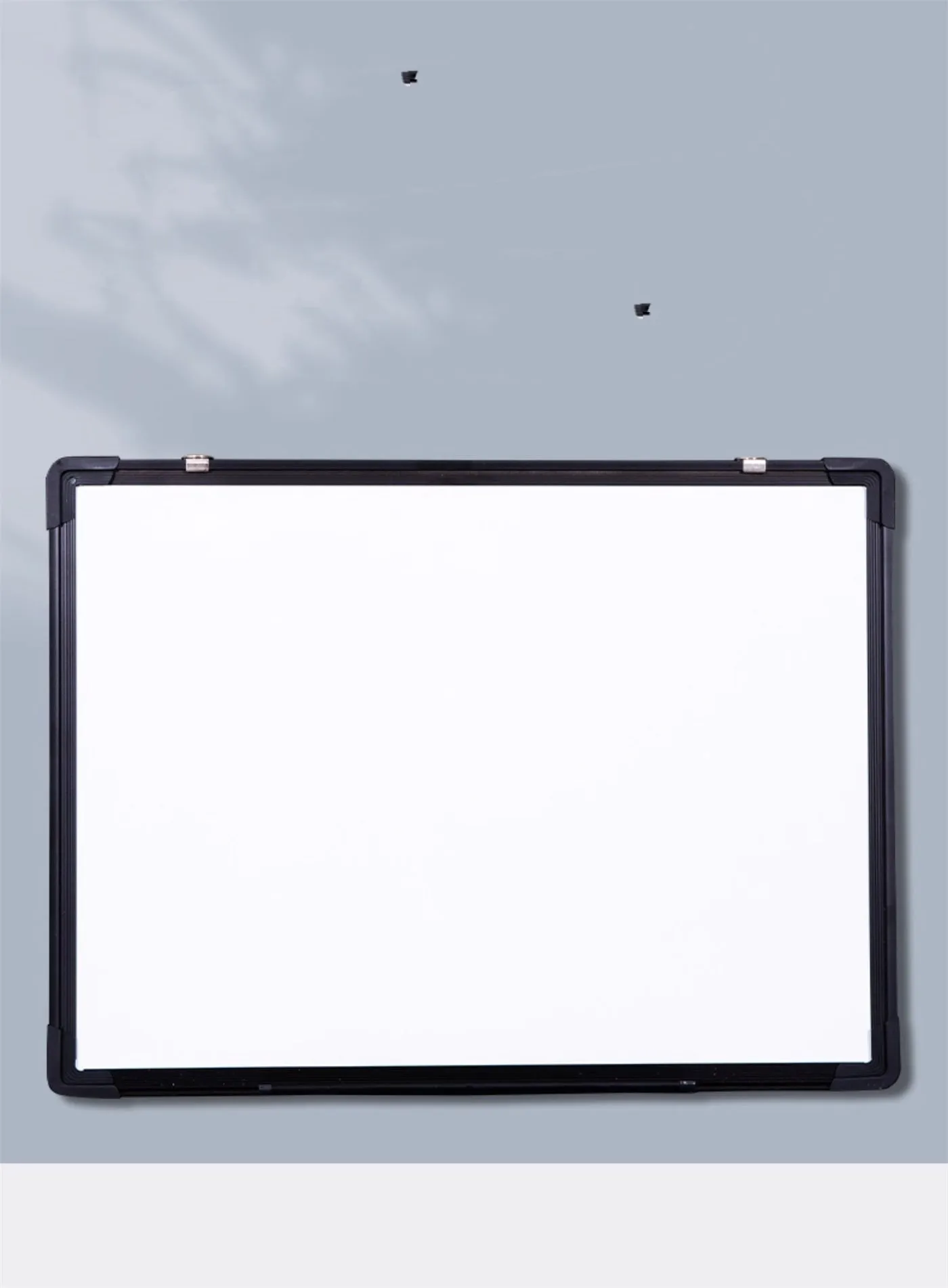 45x60cm hanging whiteboard with black frame, whiteboard pens, magnetic particles, eraser, and pen tray on a wall