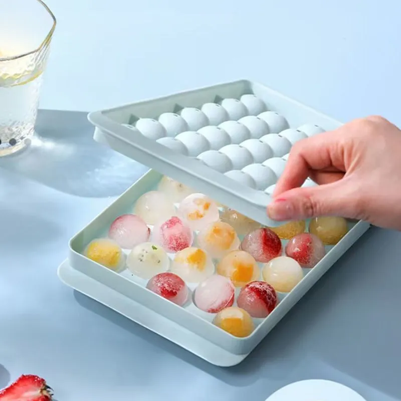 Blue silicone ice cube tray with lid showing 33 round cavities.