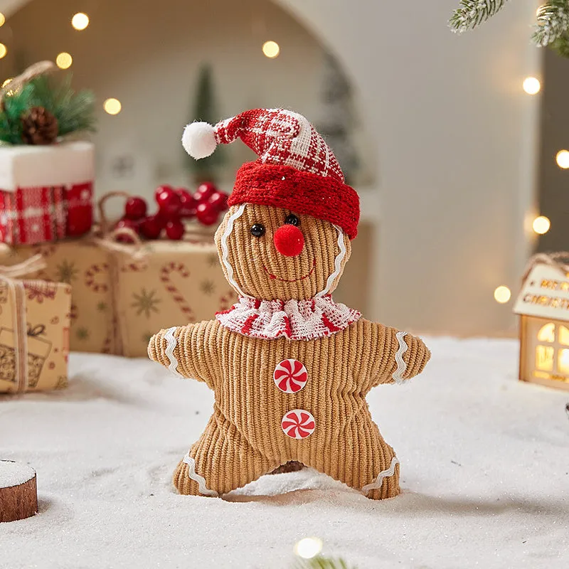 Cloth gingerbread man Christmas ornament with red hat hanging on festive branch