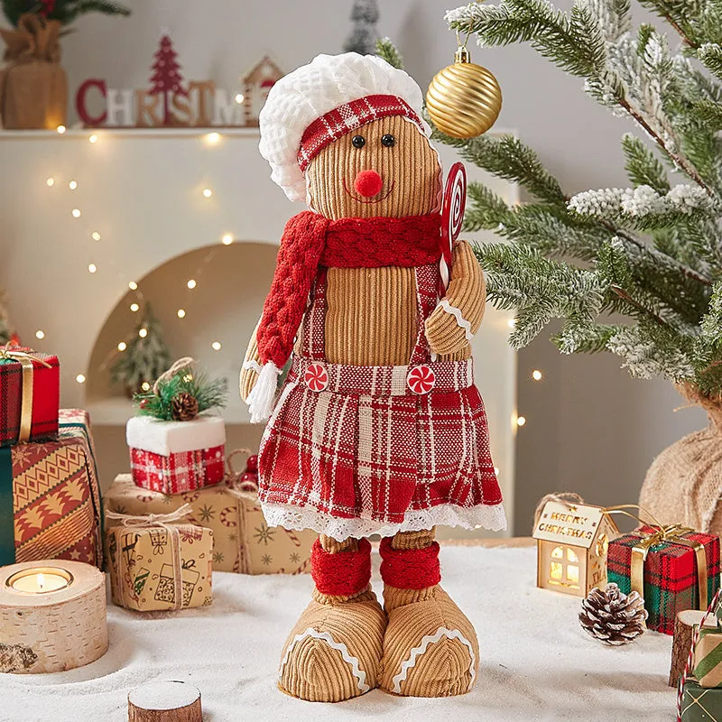 Cloth gingerbread man Christmas ornament with red hat hanging on festive branch
